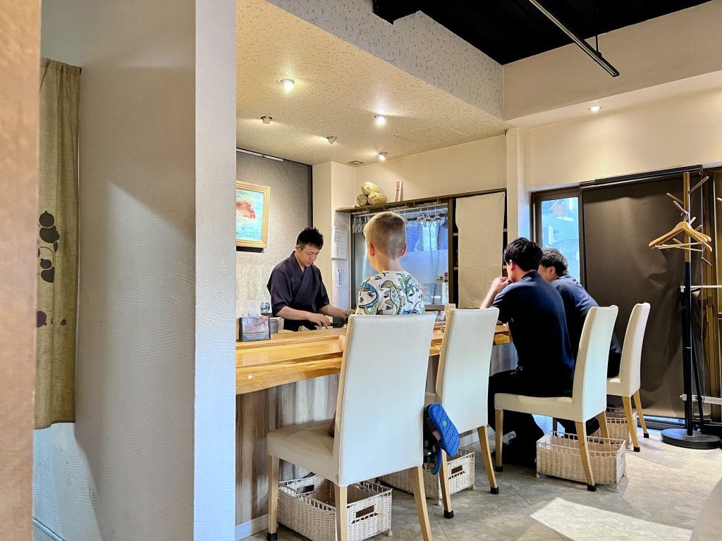 Sushi-etiquette in Japan: dit moet je weten – Kitsune Travel Mason kijkend naar sushi chef