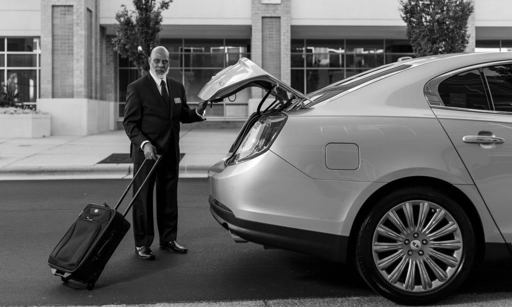 Luchthaventransfers in Japan: van Narita, Haneda en Kansai naar de stad – Kitsune Travel Chauffeur laadt bagage in voor een privétransfer