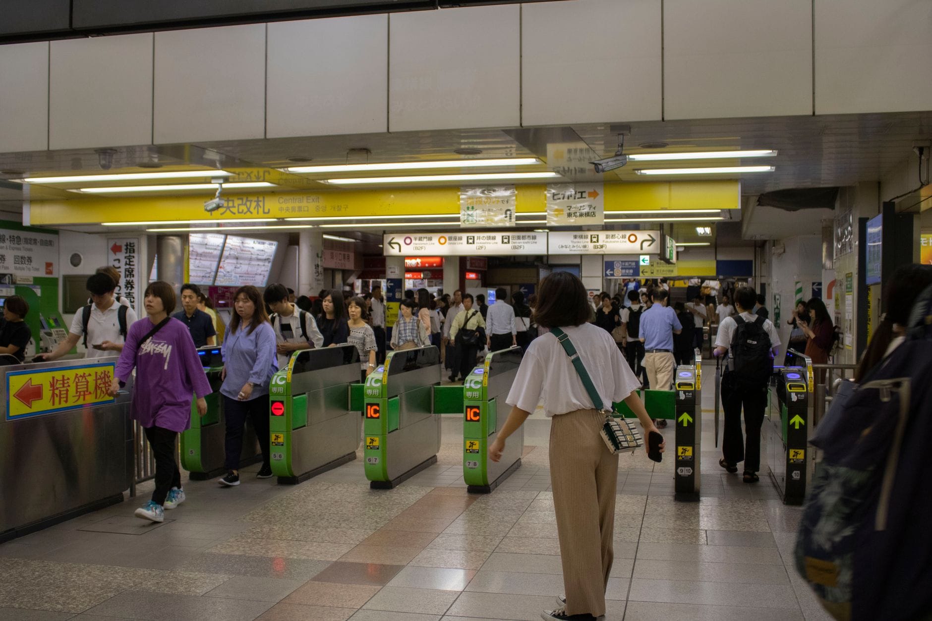 Luchthaventransfers in Japan: van Narita, Haneda en Kansai naar de stad – Kitsune Travel Een drukke ingang van een metrostation in Tokio, waar pendelaars door de poortjes gaan.