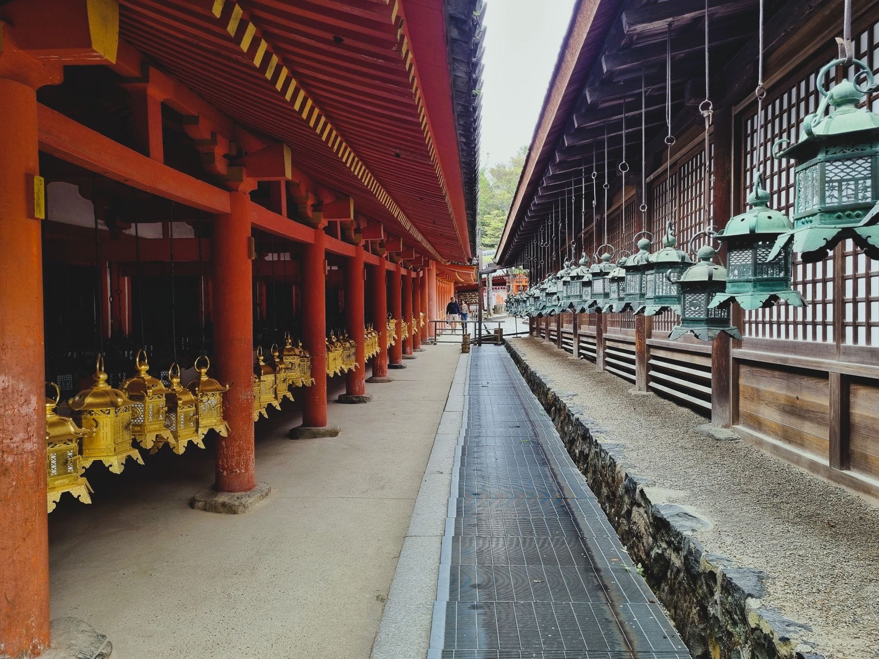 Uitzicht op een historische Japanse tempel met traditionele lantaarns en rode pilaren, die een serene sfeer creëren.