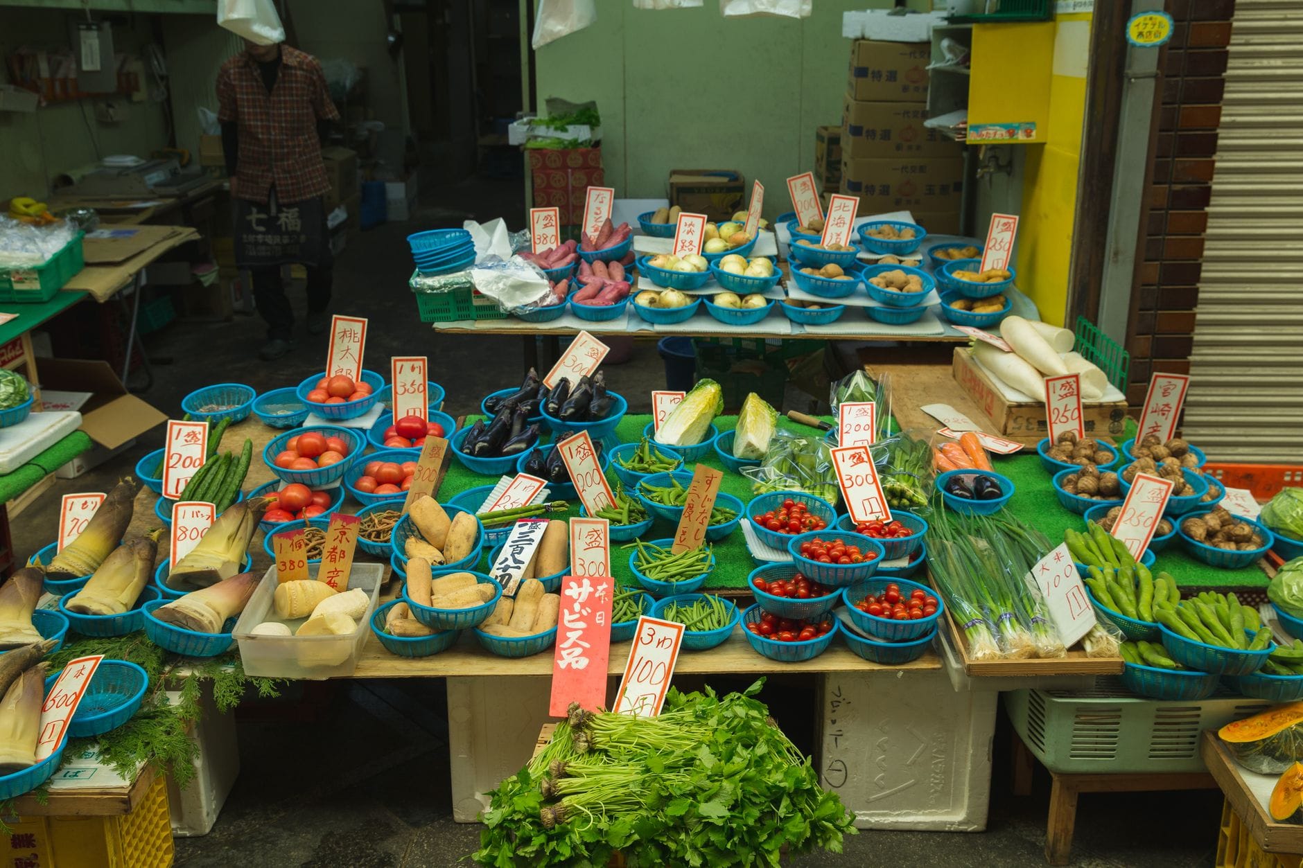 Kanazawa met kinderen – Kitsune Travel Japanse handelaar verkoopt verse tomaten en andere verse groenten aan klanten op de straatmarkt.