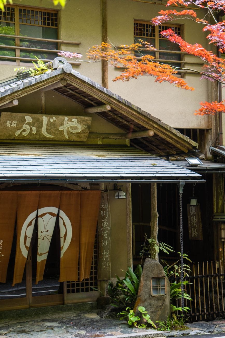 Charmante gevel van een traditionele Japanse ryokan met herfstbladeren in Kyoto, Japan.