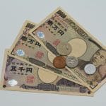 Detailopname van Japanse yen-bankbiljetten en -munten die op een plat oppervlak zijn gerangschikt.