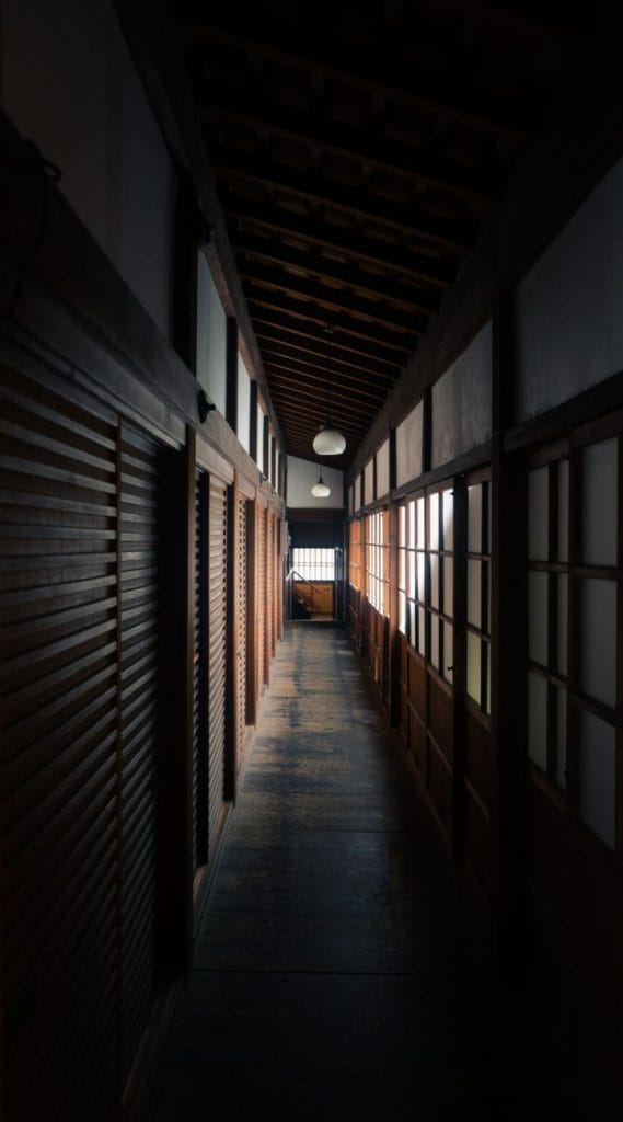Een sereen uitzicht op een traditionele Japanse gang met houten elementen in een ryokan in Kyoto.