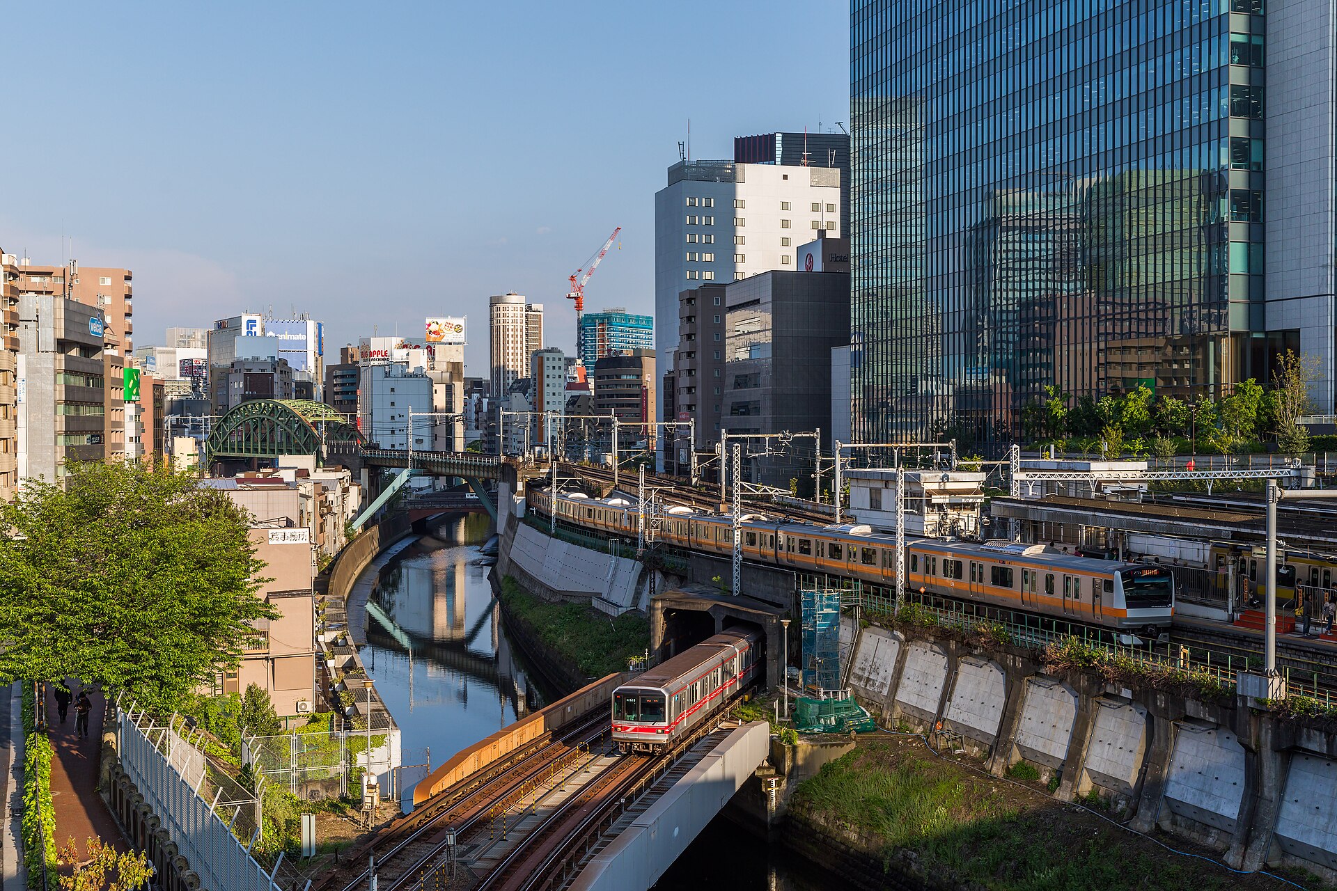 Openbaar vervoer in Tokyo: zo werkt het, van metro tot waterbus – Kitsune Travel Een metrotrein van Tokyo Metro en een oranje JR-trein rijden langs elkaar bij station Ochanomizu in Tokyo