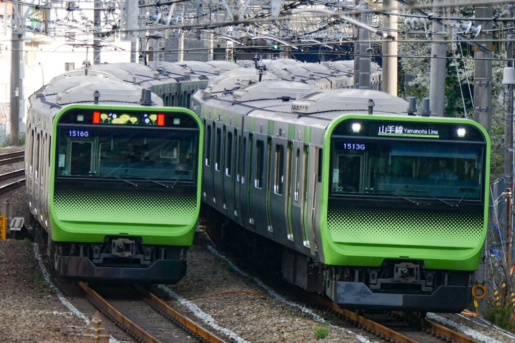 Openbaar vervoer in Tokyo: zo werkt het, van metro tot waterbus – Kitsune Travel Twee lichtgroene Yamanote-treinen naast elkaar op het spoor in Tokyo